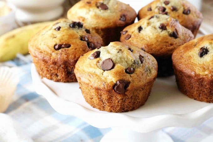 Banana and Chocolate Chip Muffins on a white scalloped cake stand. 