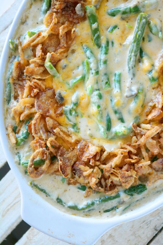 An overhead shot of homemade green bean casserole served in a while oval serving dish. 