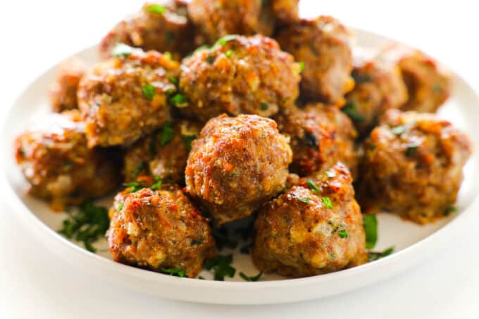 A pile of Baked Meatballs on a plate. They are browned and juicy looking.