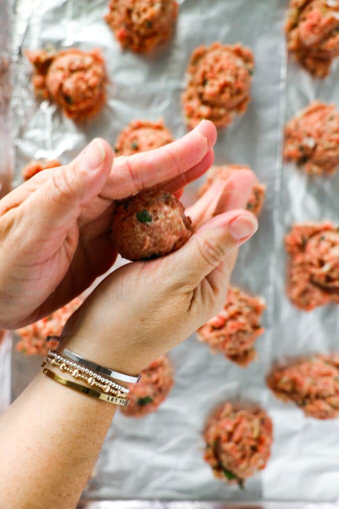 A meatball being rolled between someones hands.