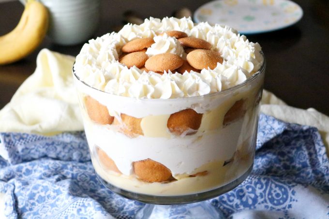 A side shot of Banana Pudding Trifle sitting on top of a blue and white napkin. 