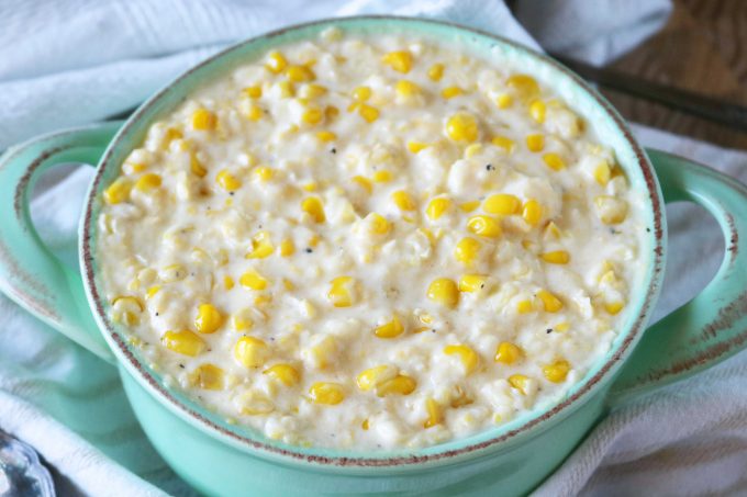 A light blue bowl of cream corn with a creamy cream corn sauce.