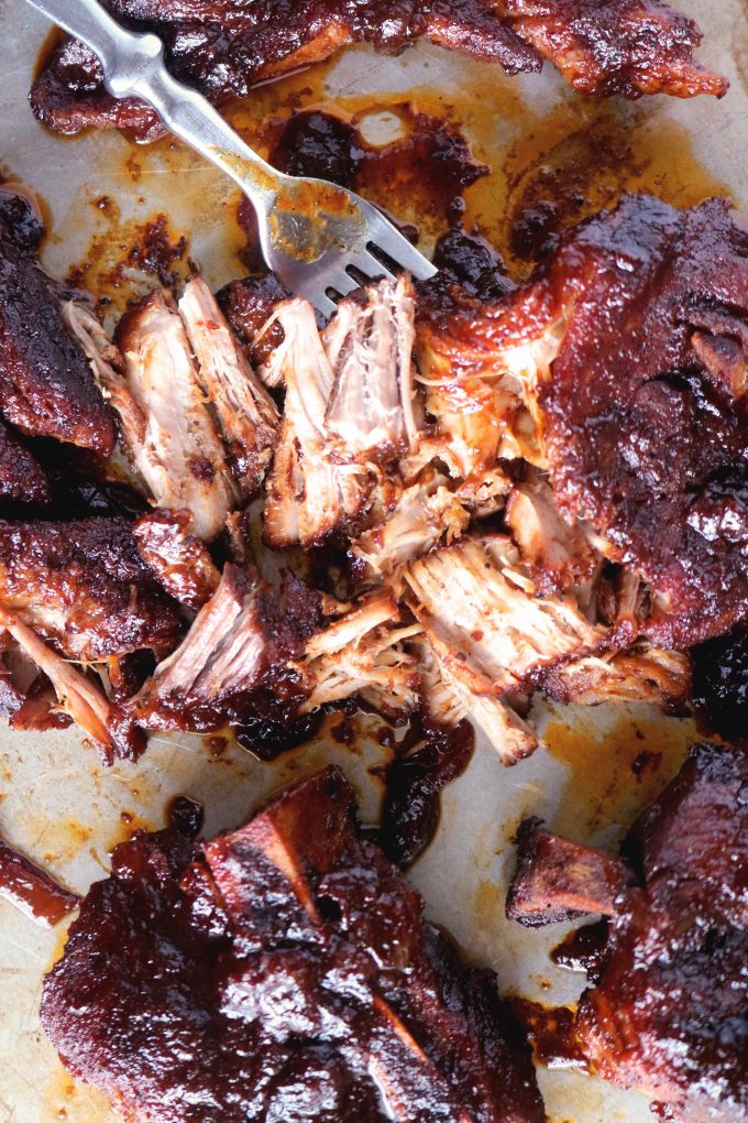 Shredded country-style pork ribs with a fork lying next to the ribs. 