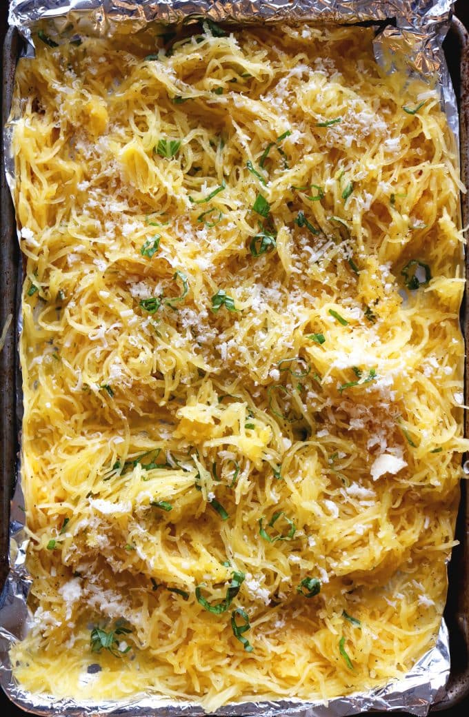 A baking sheet that is covered in foil topped with Basil-Parmesan Spaghetti Squash. 