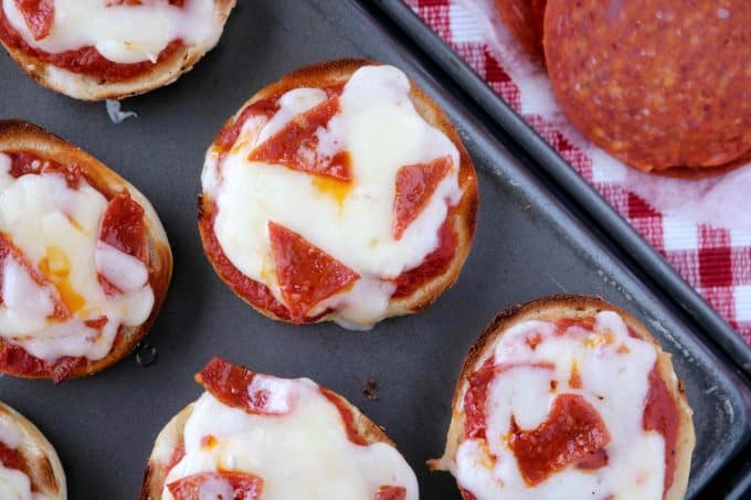 An overhead shot of pizza bagels that were cooked on a baking sheet. 