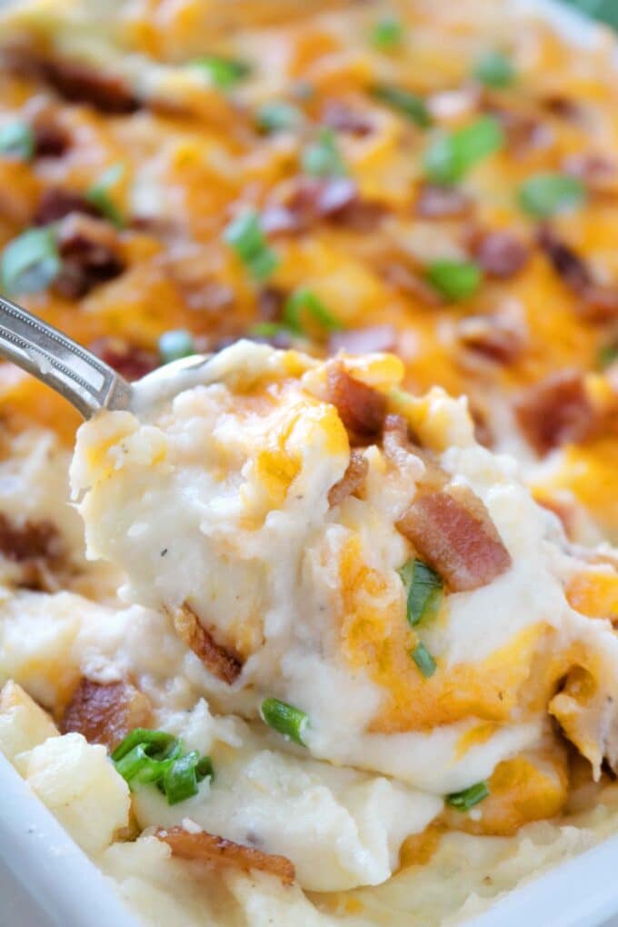 A recipe for loaded mashed potato casserole, featuring crispy thick-cut, bacon, freshly grated Cheddar cheese, and chopped green onions.