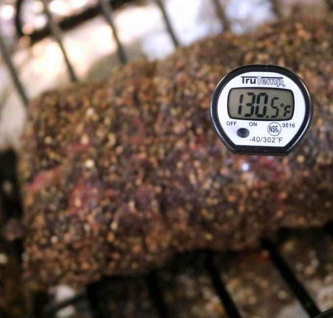 The image is focused on a digital thermometer to show the correct temperature for beef tenderloin. The thermometer reads 130. 5 degrees fahrenheit. 