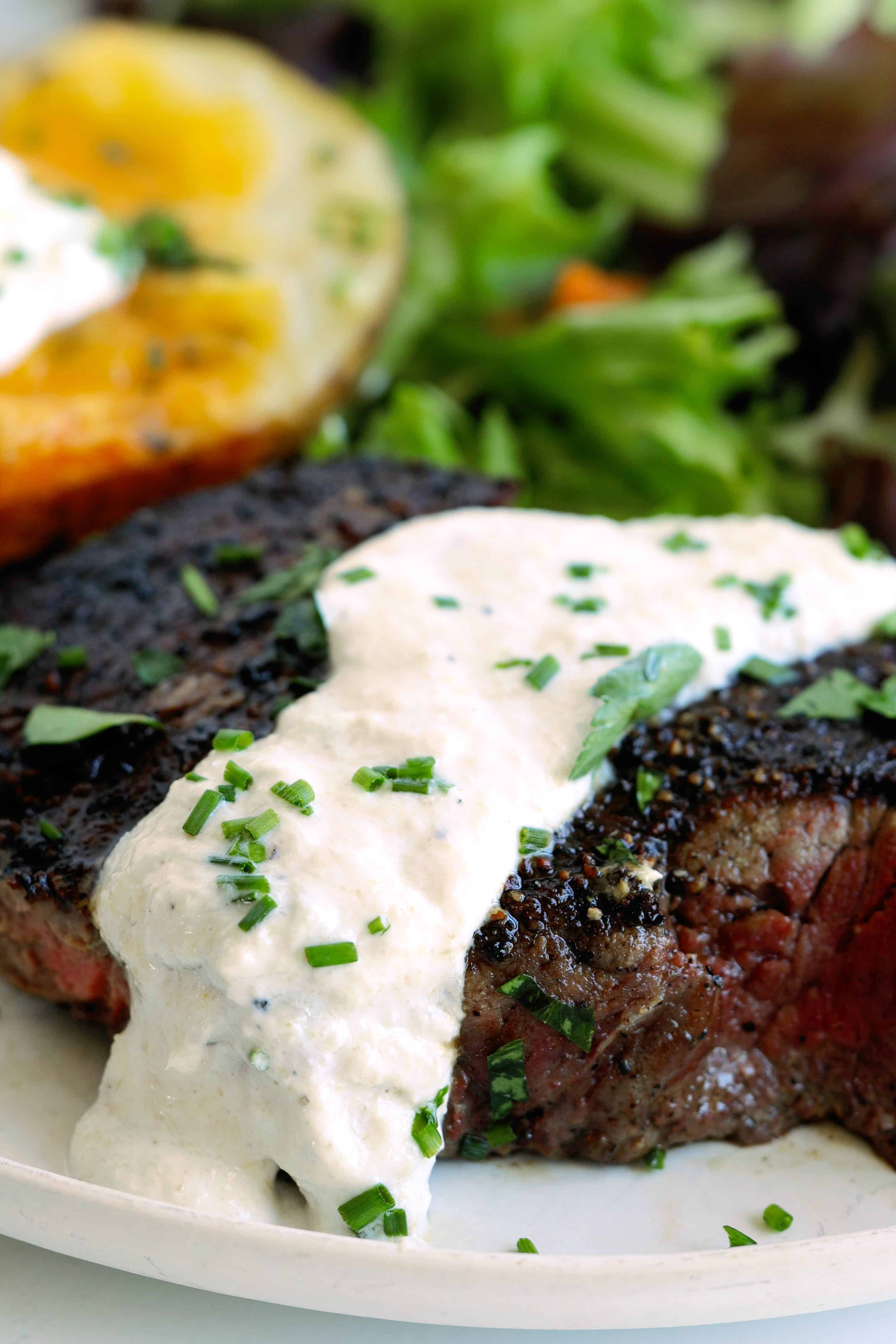 Close-up of creamy horseradish sauce served over a grilled steak