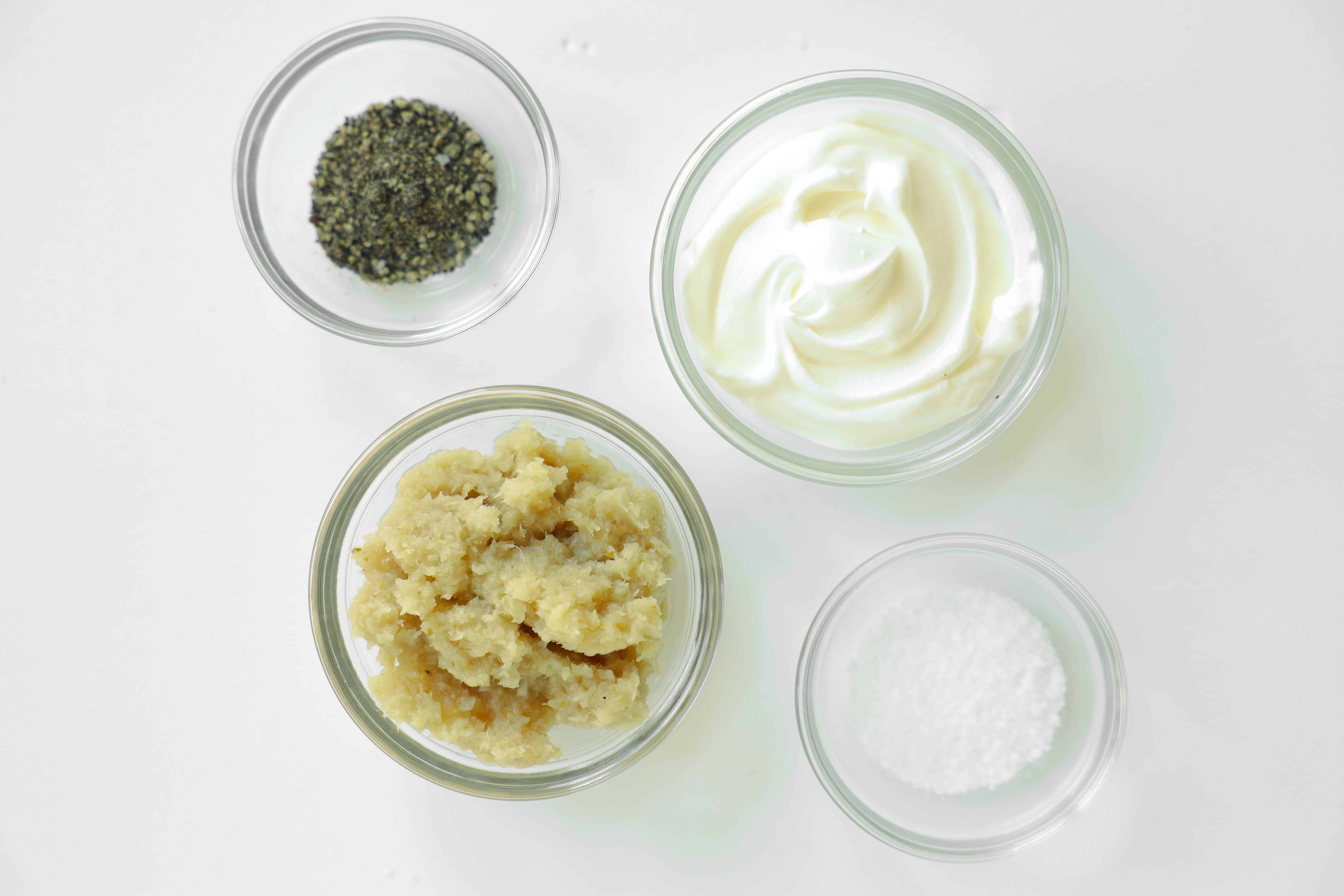 Ingredients for creamy horseradish sauce including prepared horseradish, sour cream, salt, and pepper