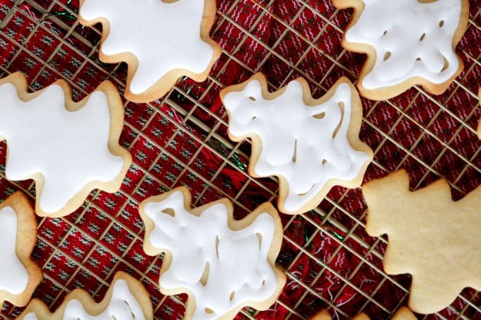 An overhead shot of Christmas tree Iced Sugar Cookies on a wire cooling rack. 