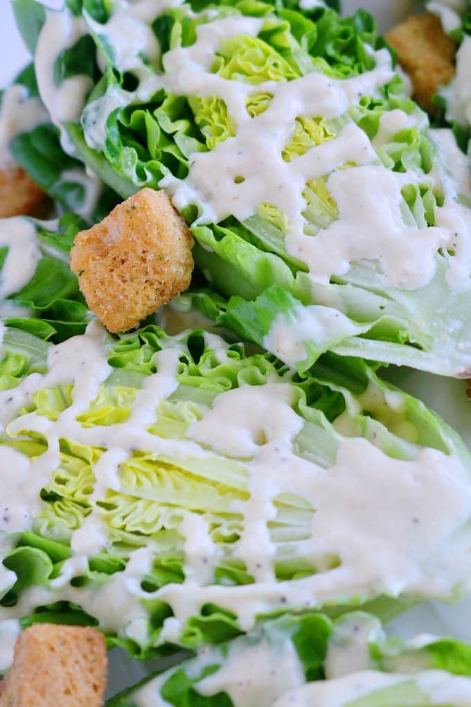 Quarters of romaine lettuce drizzled with creamy caesar dressing and sprinkled with croutons. 