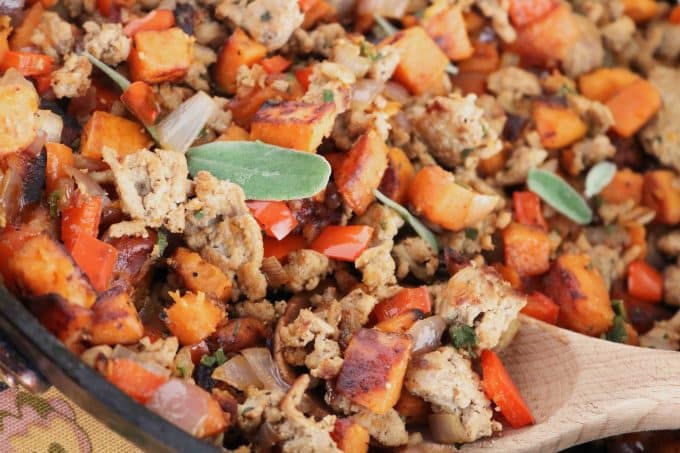 Sweet Potato Turkey Hash in a skillet with a wooden spoon resting in the dish. 