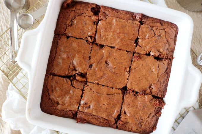 An overhead shot of Chocolate Brownies that have been sliced in squares in a white baking dish. 