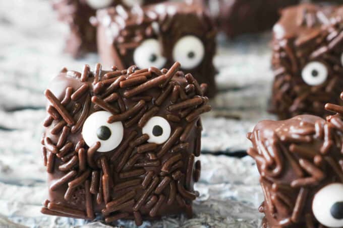 Halloween brownies covered in chocolate and chocolate sprinkles with candy eyes. 