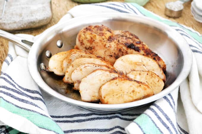 Sliced chicken breasts in a pan.