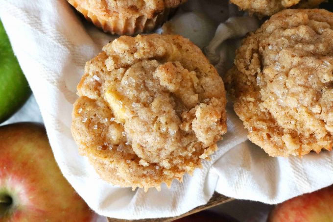 An overhead shot of Apple Crumble Muffins that are sitting on top of a white napkin. 