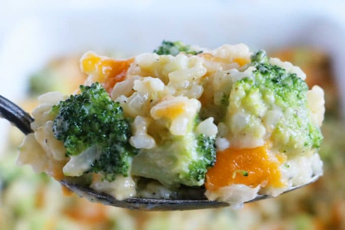 A close up shot of a spoonful of broccoli and rice casserole.