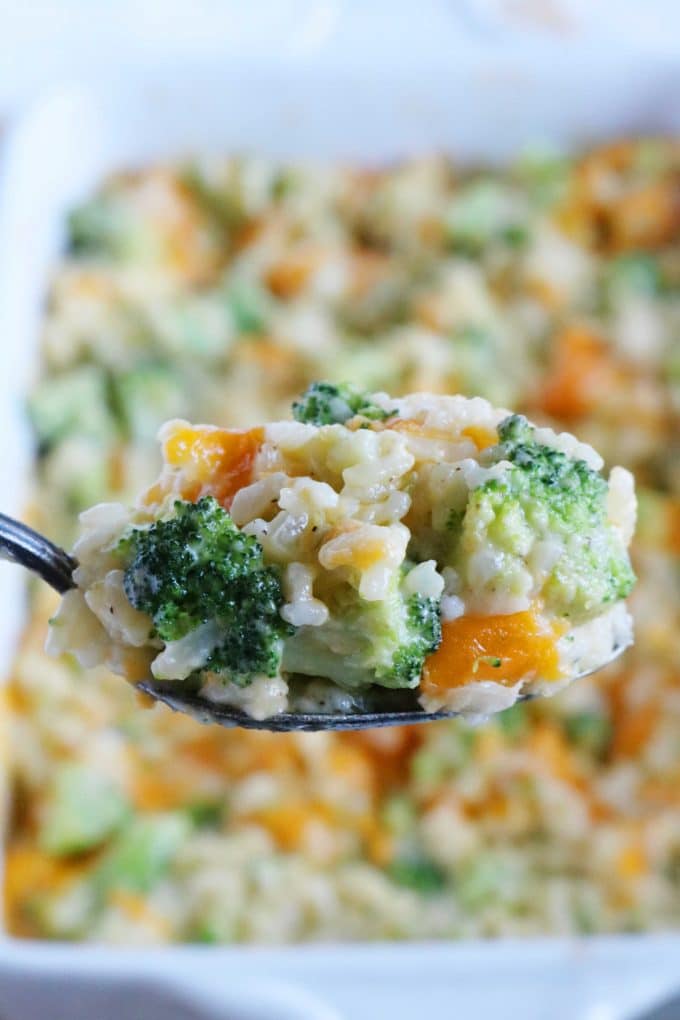 A close up shot of a spoonful of broccoli and rice casserole. 