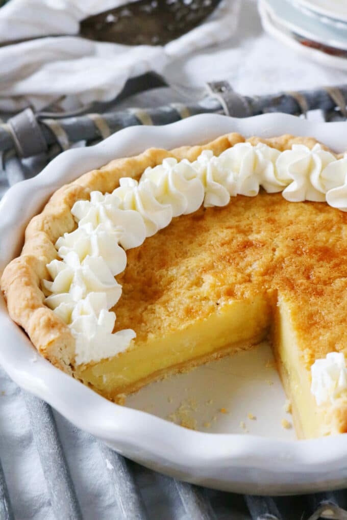 Buttermilk Pie that was cooked in a white pie dish with a slice missing. 