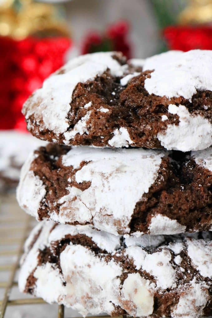 A close up shot of three chocolate crackles cookies stacked on top of each other. 