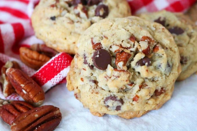 Featuring cowboy cookies with a red and white checkered napkin in the background with whole pecan pieces. . 