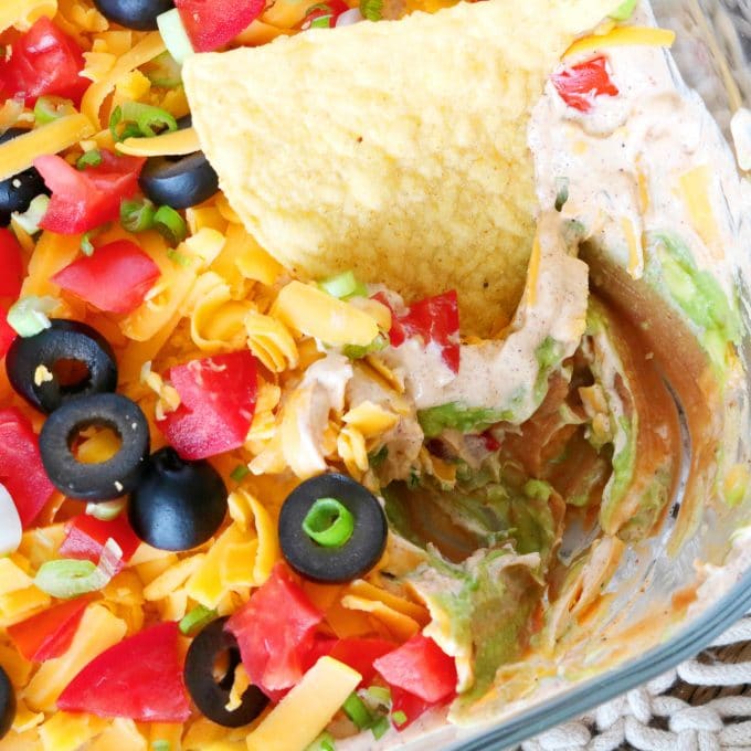 A corner overhead shot of a chip that is resting in the Mexican Layer Dip. 
