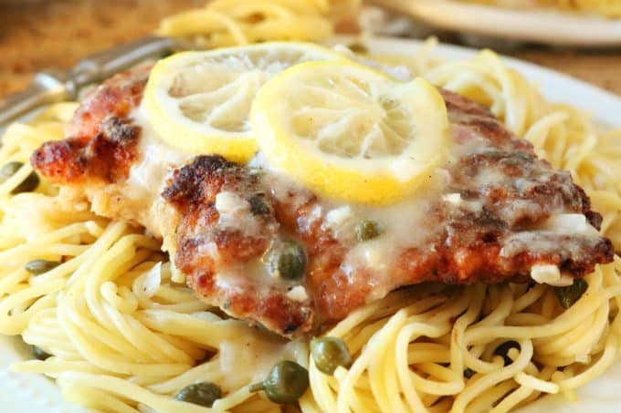 A close up shot of Chicken Scallopini with two lemon slices on top of the chicken. 