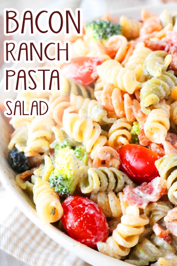 A close up shot of half of a bowl full of Bacon Ranch Pasta Salad. Underneath the bowl is a white and tan cloth napkin.