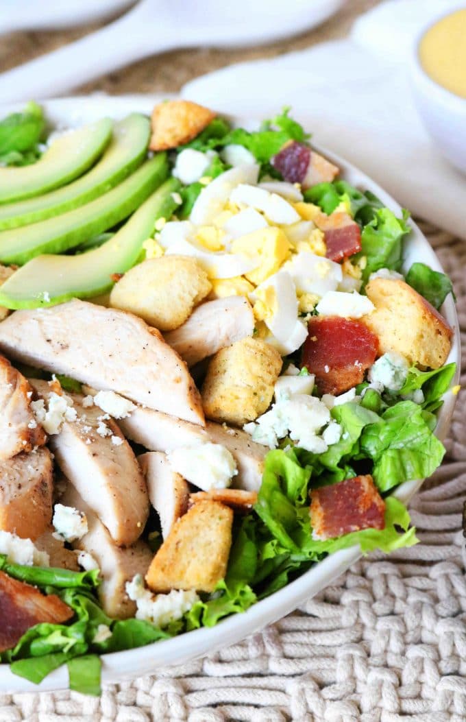 Cobb Salad with sliced Chicken served in a white bowl. 