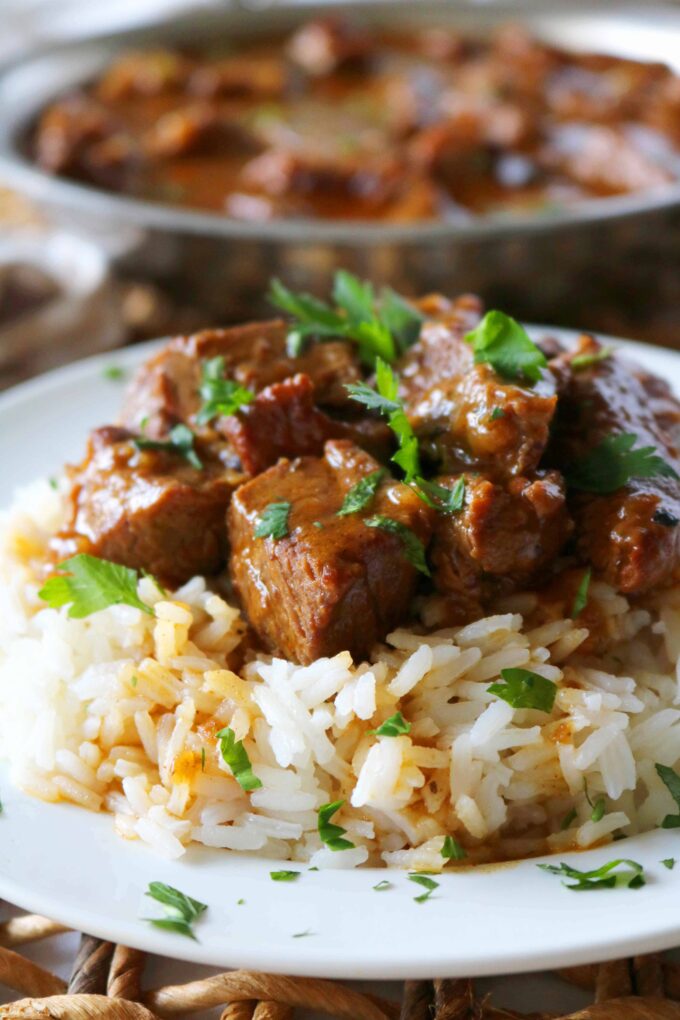 Beef Tips and Rice served on a white plate. 