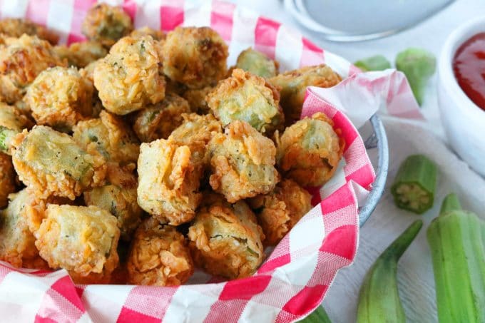 Fried Okra in a basket that is lined with a red and white checkered napkin. 