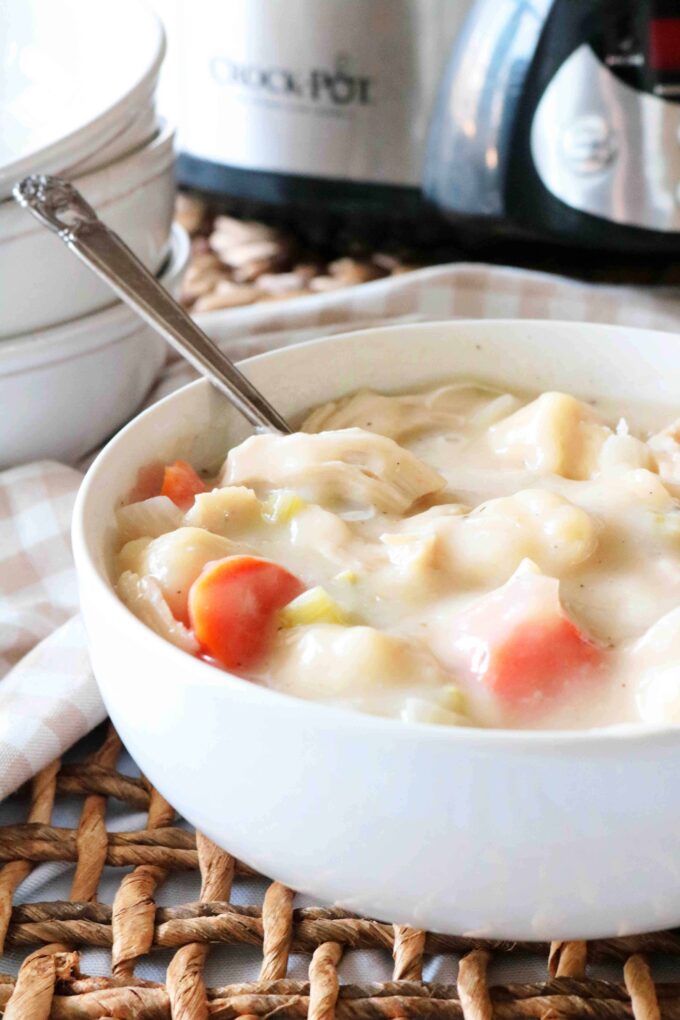 A bowl of Crock-pot Chicken and Dumplings with a spoon resting in the bowl. 