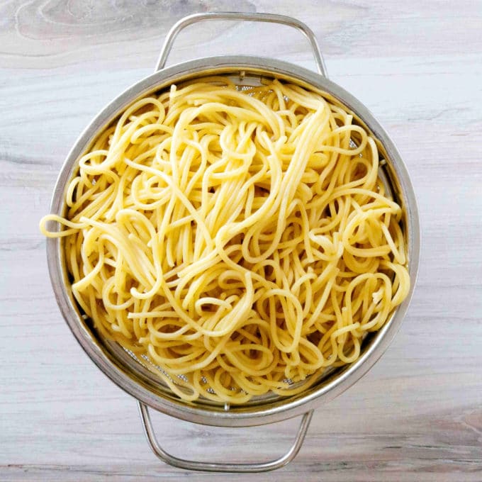 An overhead shot of cooked noodles in a colander. 