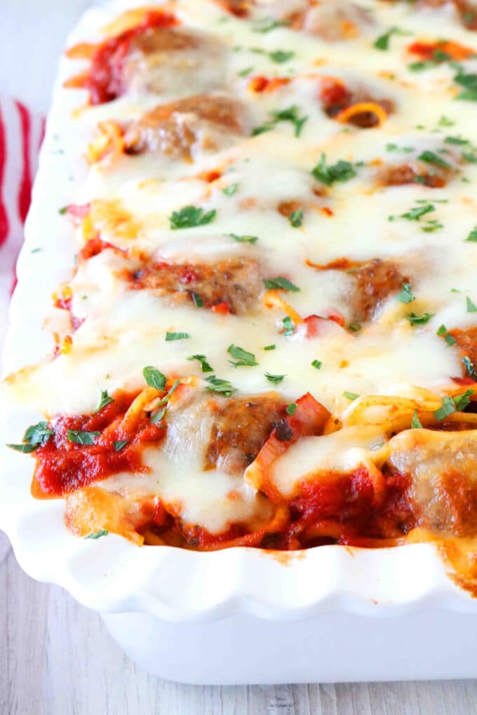A shot of half of the Meatball Casserole cooked in a white baking dish. 