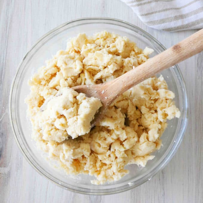 Dough in a bowl with a wooden spoon in it.