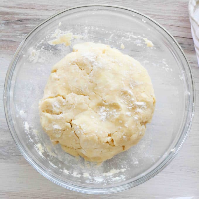 Dough in a bowl dusted with flour.