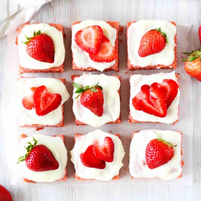 An overhead shot of strawberry brownies with cream cheese frosting.