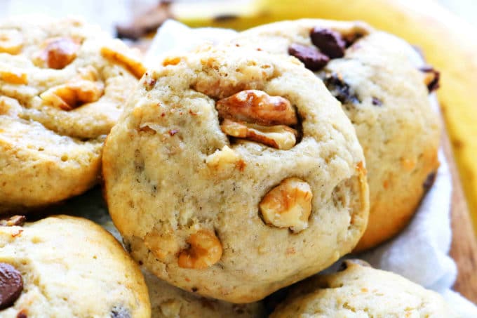 A close up shot of a banana cookie with walnuts.
