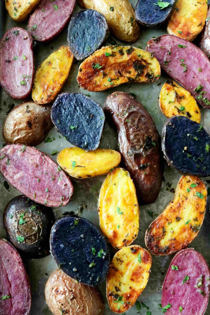 An overhead shot of potatoes laid out and roasted on a baking sheet. 