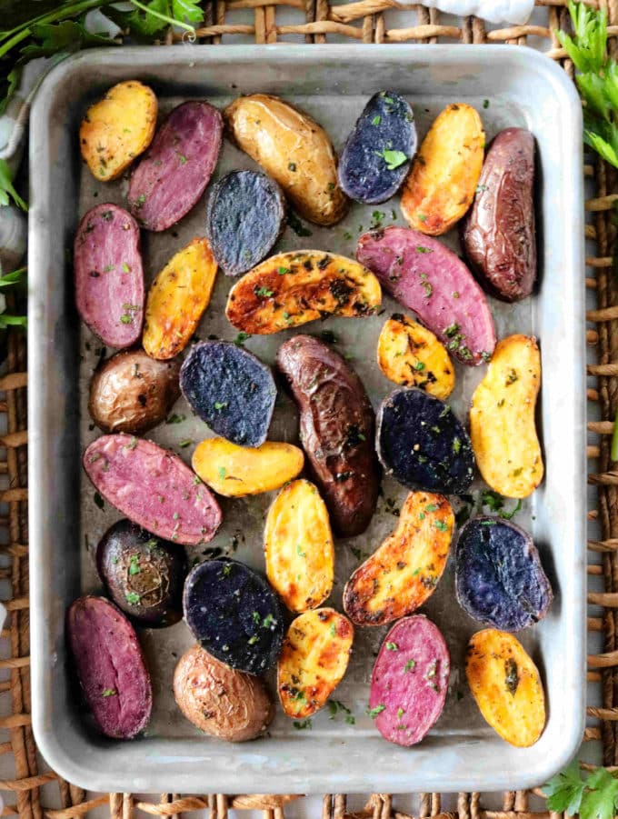 Fingerling potatoes roasted on a baking sheet until perfectly golden brown and crispy.