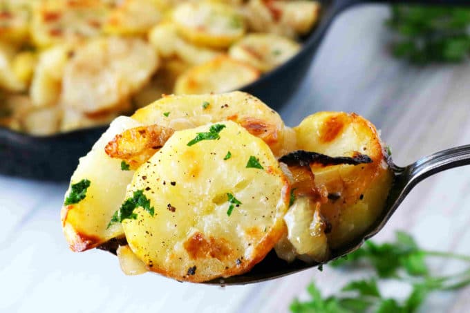 A spoonful of potatoes sprinkled with parsley.