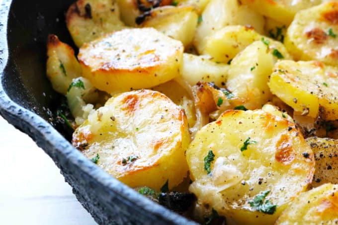 A close-up shot of Lyonnaise Potatoes in a cast iron skillet.