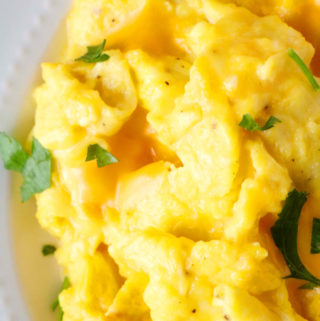 A close up shot of scrambled eggs with cheese.