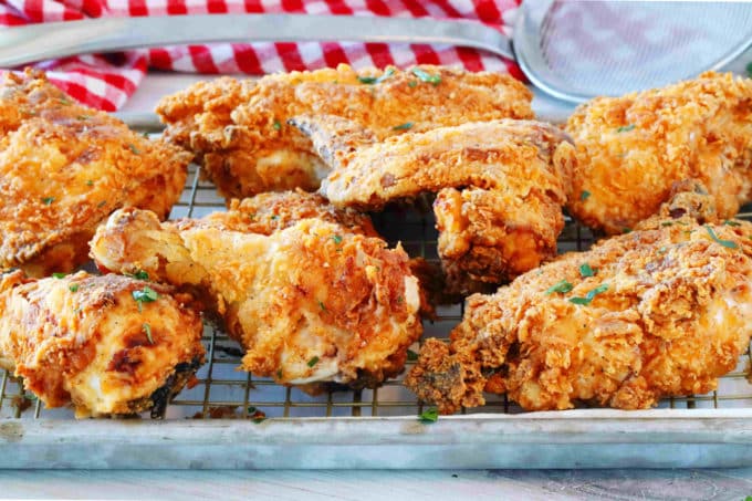 Mixed buttermilk fried chicken pieces on a cooling rack.