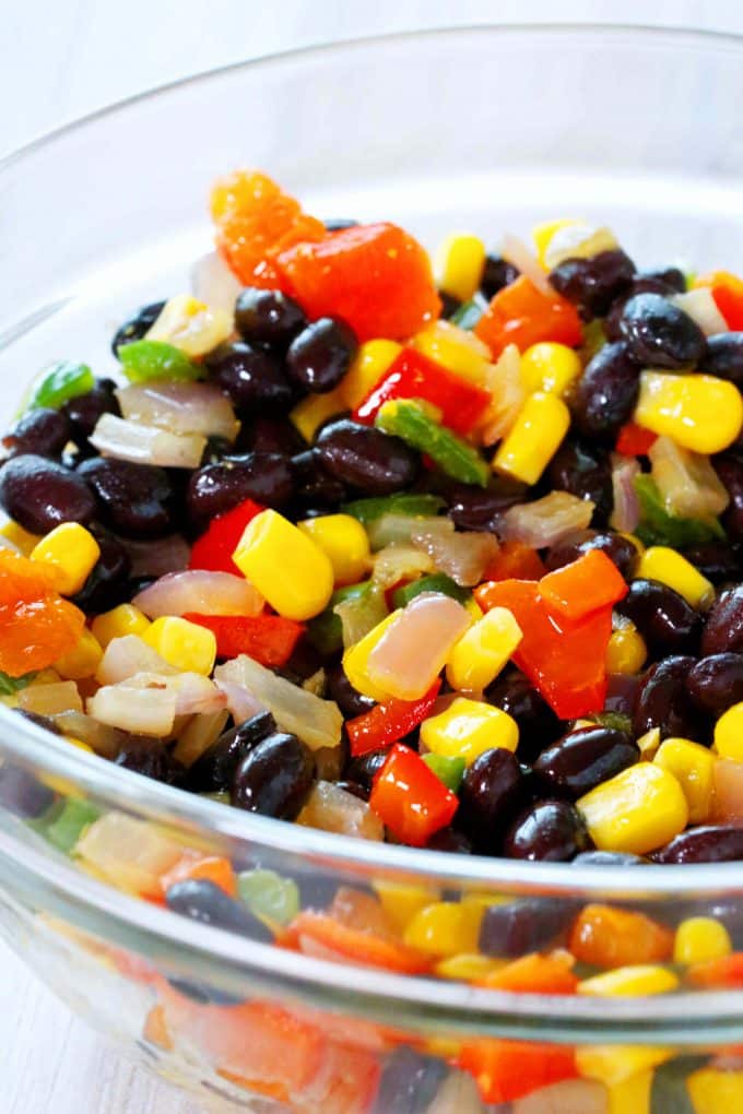 A bowl of cooked vegetables: Corn, black beans, onions, and peppers.