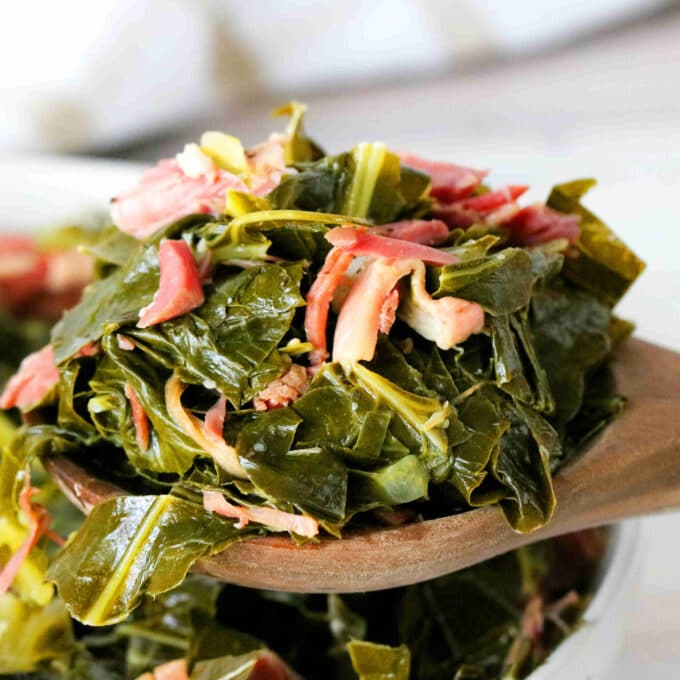 Collared Greens on a spoon with shredded ham hock on top.