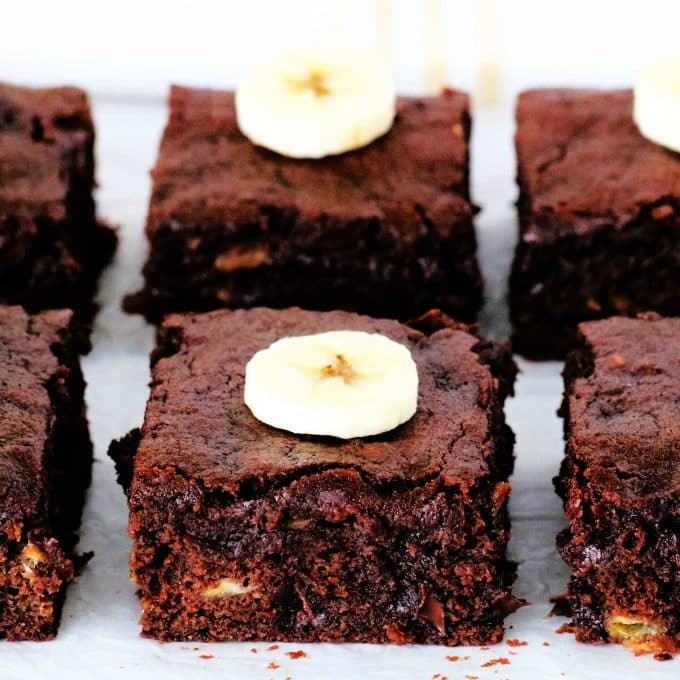 Banana brownies cut into squares with a slice of banana on top.