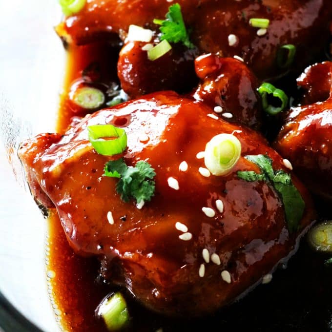 A close up shot of a baked teriyaki chicken thigh in a casserole dish. 