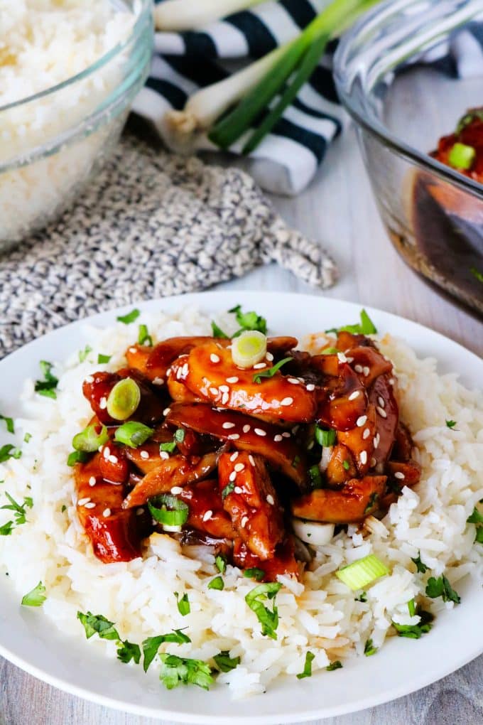 Baked Teriyaki Chicken over white rice with white rice and a casserole dish off to the side. 