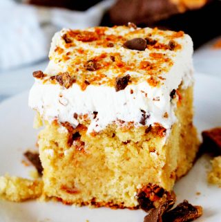 A slice of Butterfinger Cake on a white plate.